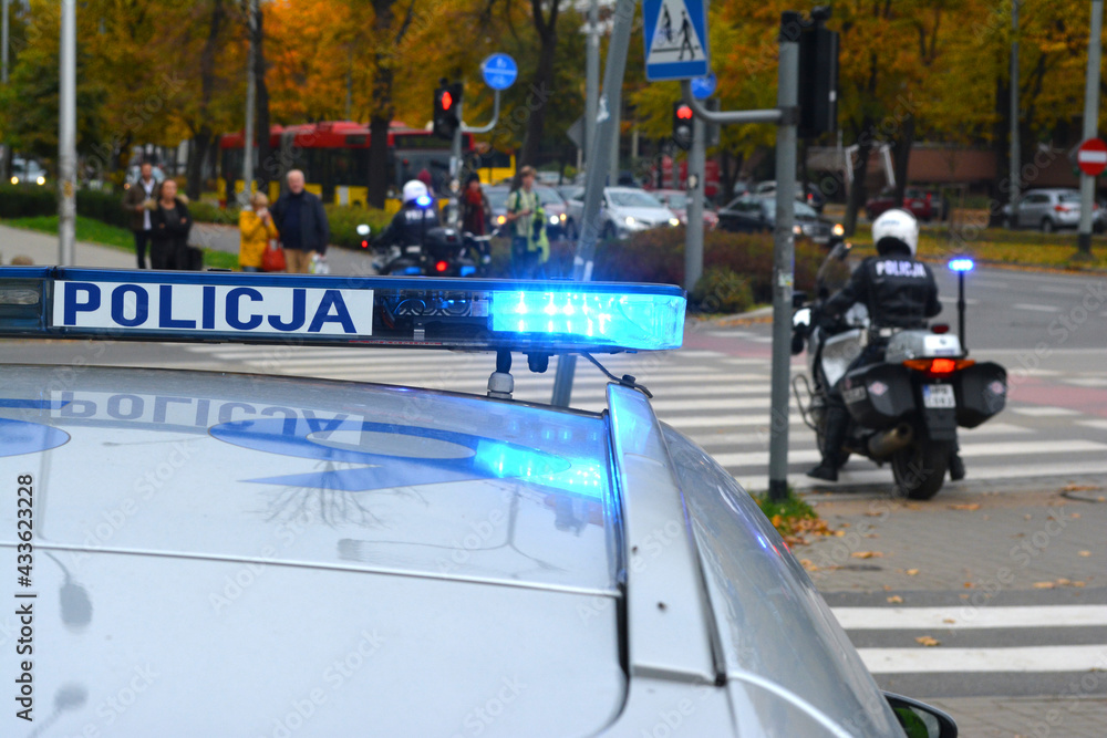 Policjant wydziału ruchu drogowego z motocyklem podczas kontroli miasta.  - obrazy, fototapety, plakaty 