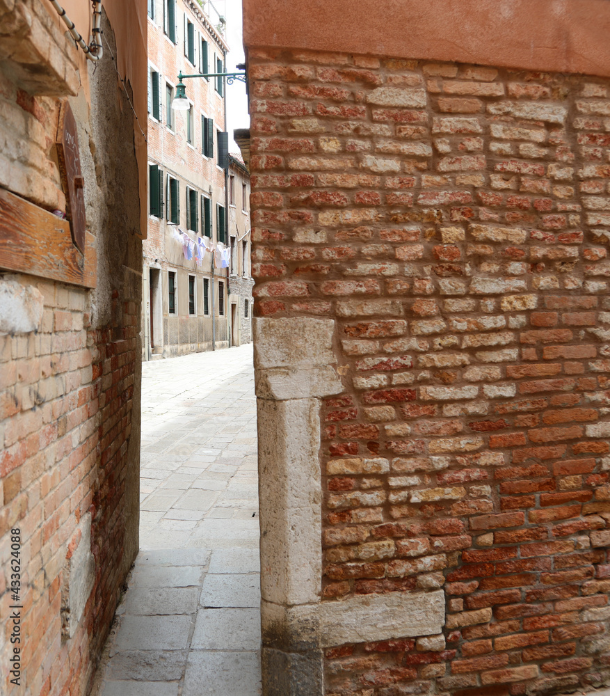 very narrow passage between the houses of the city of Venice in Italy with the streets called CALLI