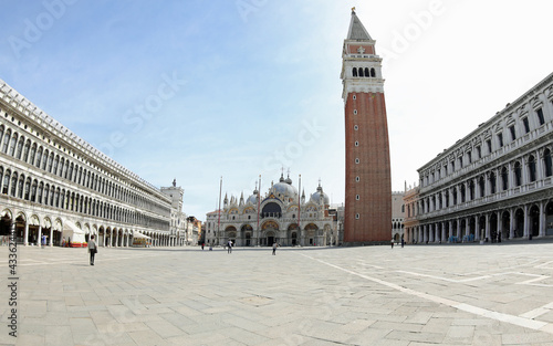 Piazza San Marco also called Saint Mark Square in Venice with the Basilica and the high bell tower with very few people during the lockdown