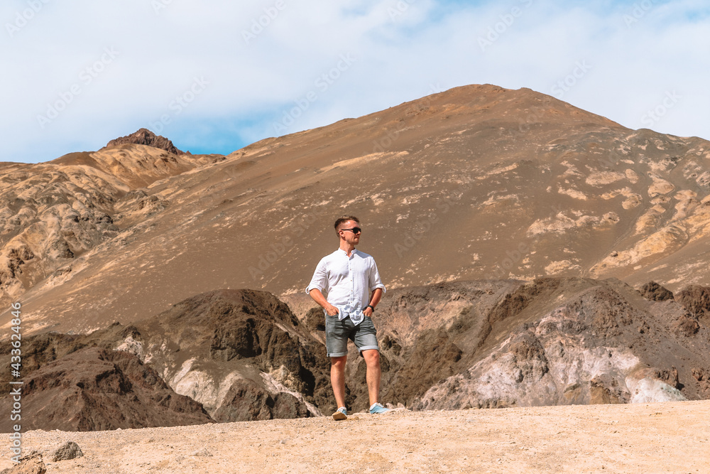 A young man stands on a hill in The Artist's Palette, Death Valley