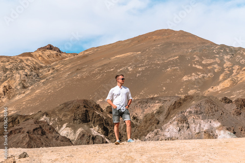 A young man stands on a hill in The Artist's Palette, Death Valley