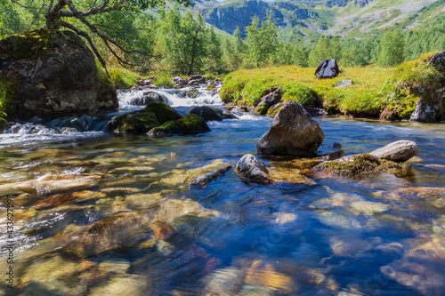 a mountain river carries its stream through a rocky bed