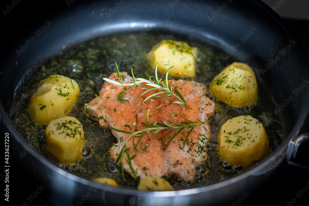fresh cooking at home and ready to eat - grilled salmon fillet with rosemary and fried potatoes in butter and herbs