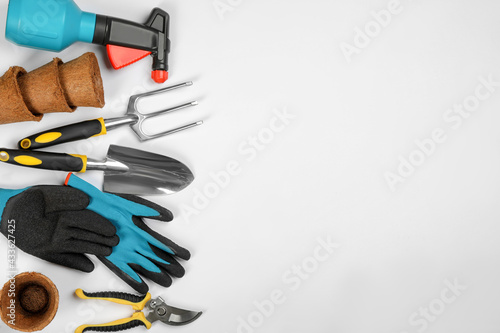 Flat lay composition with gardening tools on white background, space for text