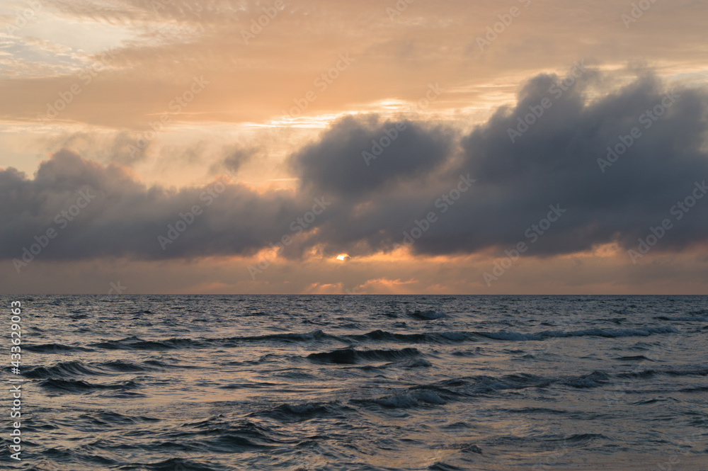 Fototapeta premium 夕暮れの空と小さくうねり波の立つ海岸