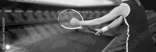 Composition of midsection of woman playing tennis over sports stadium in black and white