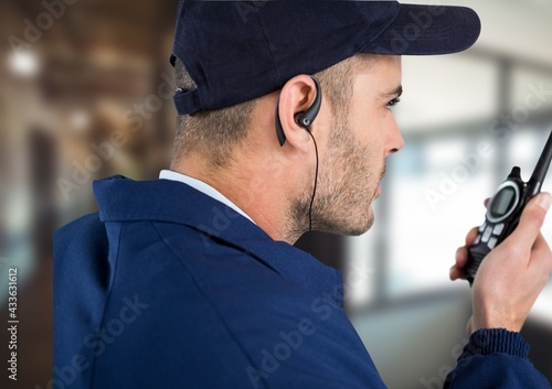 Composition of male security guard using walkie talkie and phone headset over blurred background photo