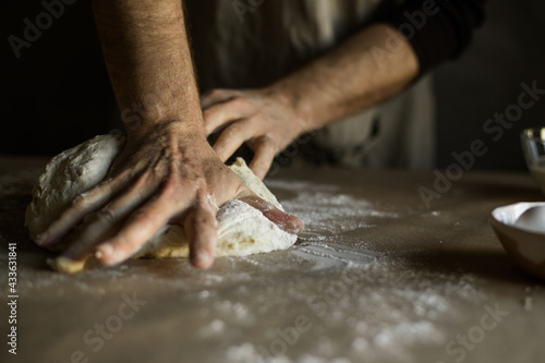 Fototapeta Naklejka Na Ścianę i Meble -  Male hands kneading dough on the table