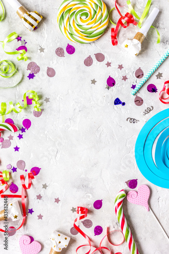 Colored party sweets and confetti on stone background top view mockup