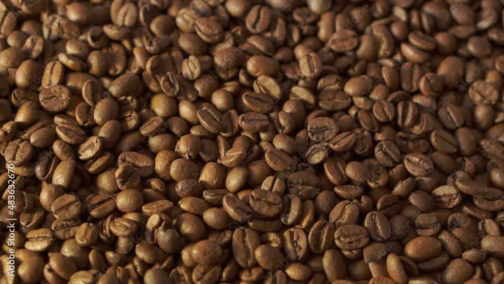 Coffee beans in rotation. Mixed Robusta and Arabica roasted Coffee beans. Coffee background. Close up of seeds of coffee. Coffee beans in rotation. Mixed Robusta and Arabica roasted Coffee beans. Coffee background. Close up of seeds of coffee.