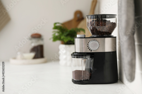Modern coffee grinder on counter in kitchen