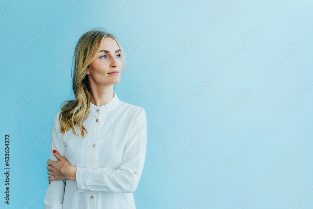 Young fashion white blonde woman in a white dress robe on a blue background. Young fashion white blonde woman in a white dress robe on a blue background.
