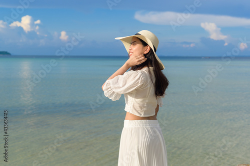 A happy beautiful woman in white dress enjoying and relaxing on the beach, Summer and holidays concept