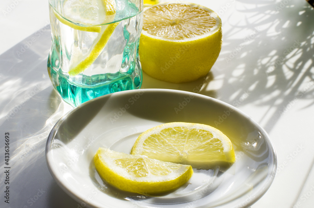 Lemon drink, fresh lemon and glasses. Summer tropical composition, vacation refreshment concept. Long harsh shadows. Summer and holiday mood. Flatly, top view, yellow Lemon drink, fresh lemon and glasses. Summer tropical composition, vacation refreshment concept. Long harsh shadows. Summer and holiday mood. Flatly, top view, yellow