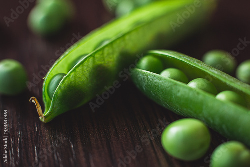 Green pea pods on brown wooden table. Macro