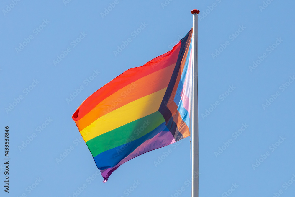 Worldwide LGBTQ community concept with progress pride flag (new design of rainbow flag) waving in the air with blue sky, Celebration of gay pride, The symbol of lesbian, gay, bisexual and transgender. Worldwide LGBTQ community concept with progress pride flag (new design of rainbow flag) waving in the air with blue sky, Celebration of gay pride, The symbol of lesbian, gay, bisexual and transgender.