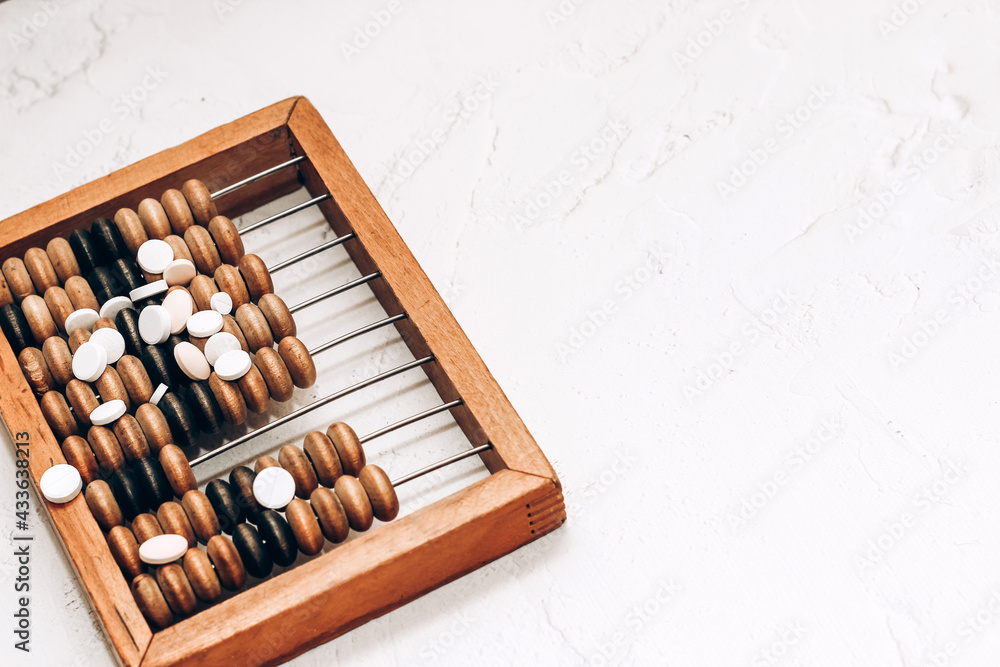 Wooden abacus with pills and vitamins on white background. Wooden abacus with pills and vitamins on white background.
