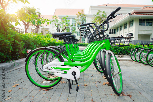 App bicycles for city bike-sharing, parking in a public area. concept of eco-friendly healthy active lifestyle, business transport. The row of many green modern bicycle on public parking in university