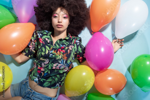 Young multiethnic woman posing with balloon serious and concerned © Eugenio Marongiu