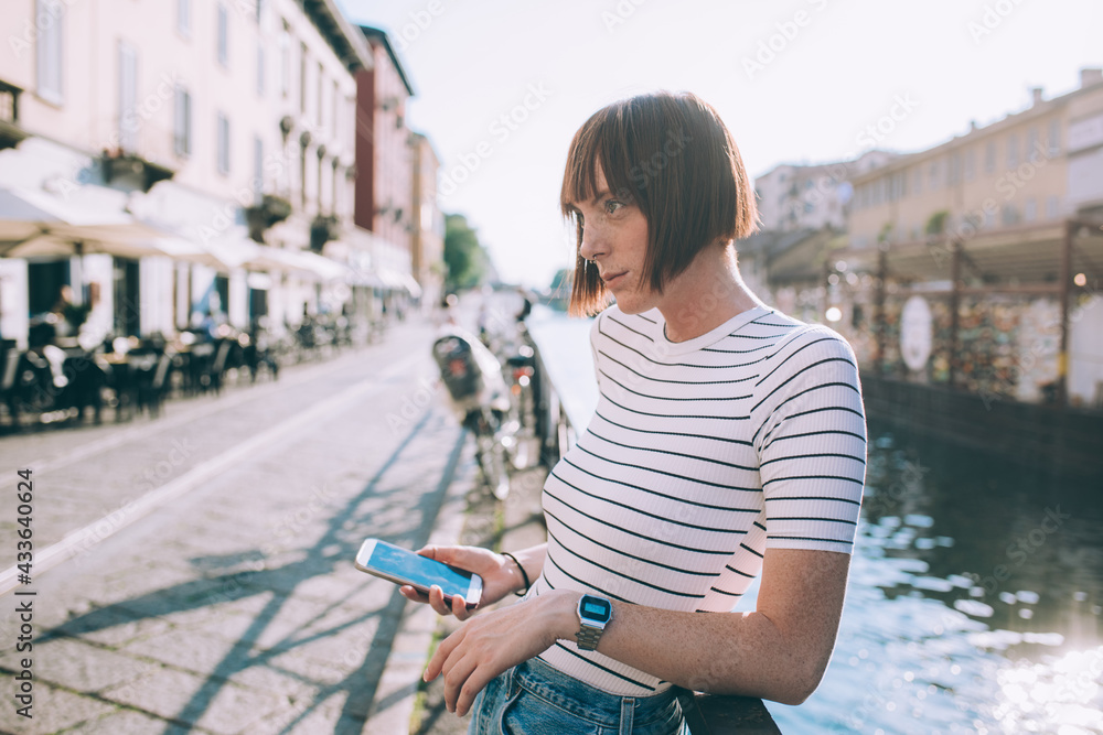 Young woman outdoors holding smartphone