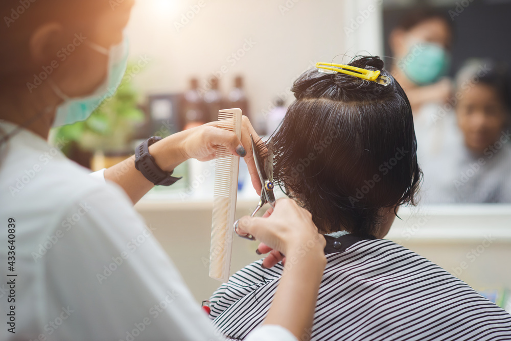 Asian woman barber wears green mask cut black, white hair old customer. beautiful hairstylist trimming with scissors in haircut. female Hairdresser working in Thai stylist beauty salon Asian woman barber wears green mask cut black, white hair old customer. beautiful hairstylist trimming with scissors in haircut. female Hairdresser working in Thai stylist beauty salon