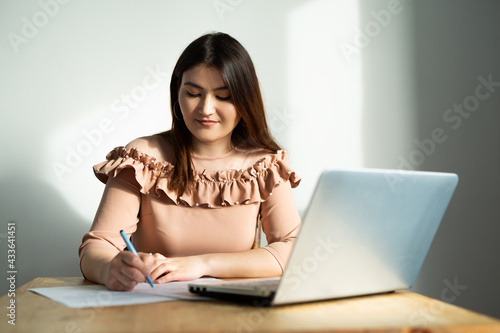 beautiful young caucasian woman at the table with laptop  © Alexandr