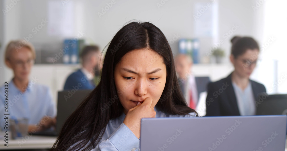 Worried stressed businesswoman looking at laptop screen sitting in office Worried stressed businesswoman looking at laptop screen sitting in office