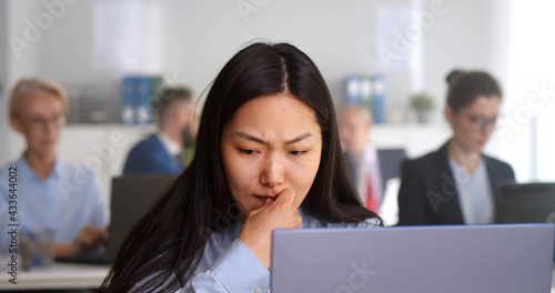 Worried stressed businesswoman looking at laptop screen sitting in office