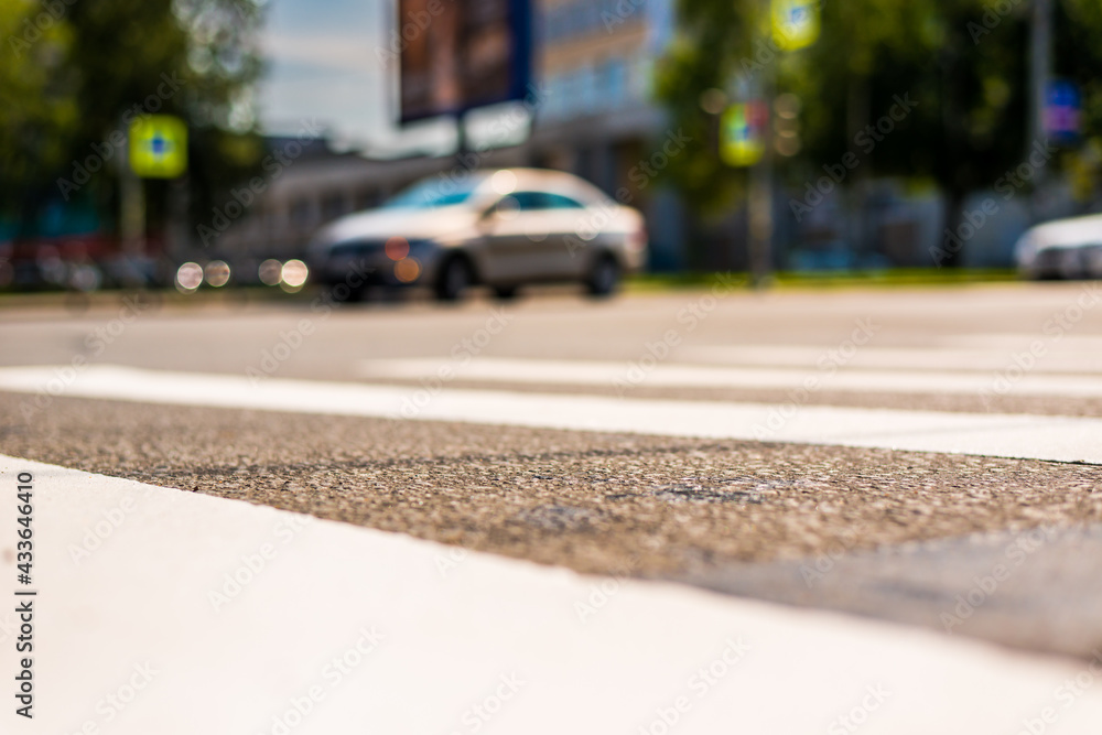 Summer in the city, the car turns at the crossroads. View from the pedestrian crossing level Summer in the city, the car turns at the crossroads. View from the pedestrian crossing level