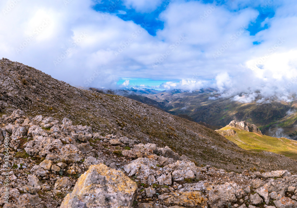landscape full of rocks in the heights of the Andes de Peu looking at the horizon other hills and snow-capped mountains covered with ice on a cloudy and sunny day landscape full of rocks in the heights of the Andes de Peu looking at the horizon other hills and snow-capped mountains covered with ice on a cloudy and sunny day