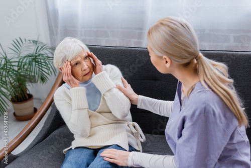 Εκτύπωση καμβά aged woman, suffering from memory loss, looking at social worker touching her on
