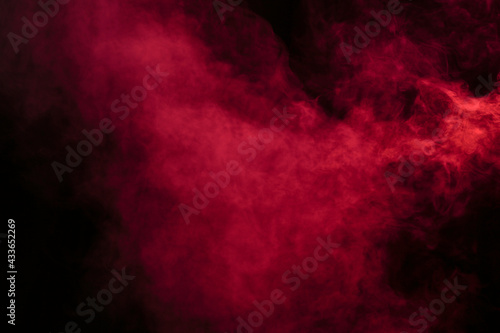 Smoke in red light on black background