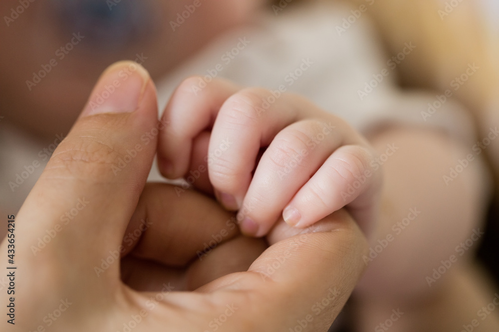 Close up of caucasian toddler holding finger of his mother Close up of caucasian toddler holding finger of his mother