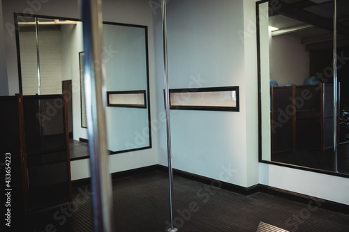 Interior of an empty pole dance and fitness studio with mirrors on walls