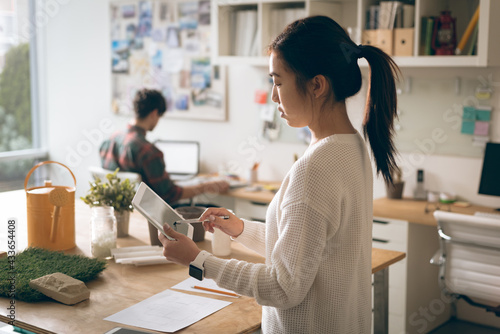 Asian creative businesswoman using tablet in creative office photo