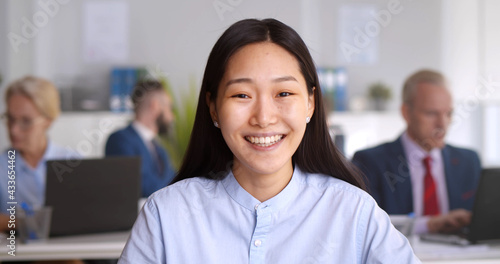 Smiling asian business woman talk to webcam make video conference sitting in open space office © nimito