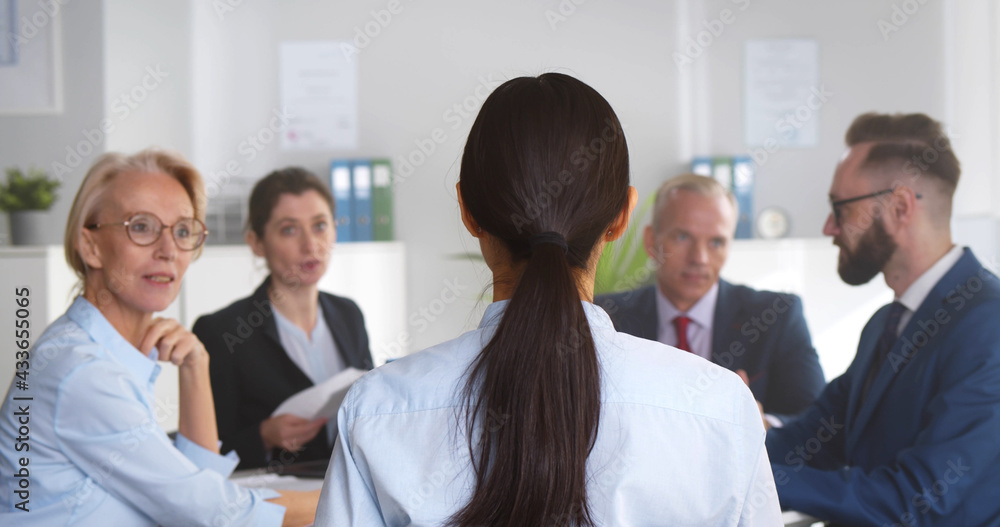 Group of business people sitting around office desk and discussing project together Group of business people sitting around office desk and discussing project together
