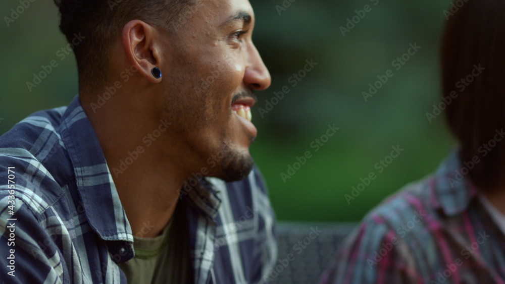 Obraz premium Positive friends gathering together outside. African man smiling at summer party