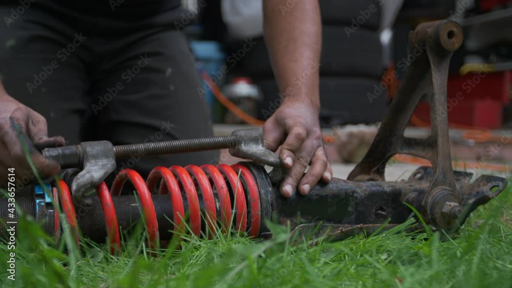 Video „Mechanic Is Fixing The Coil Spring And Car Suspension System