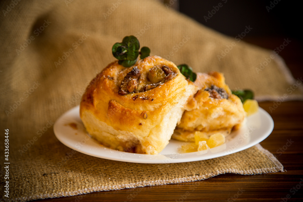 Sweet curled bun with jam, raisins in powdered sugar Sweet curled bun with jam, raisins in powdered sugar