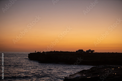 Sunrise golden sky silhouette view of people fishing