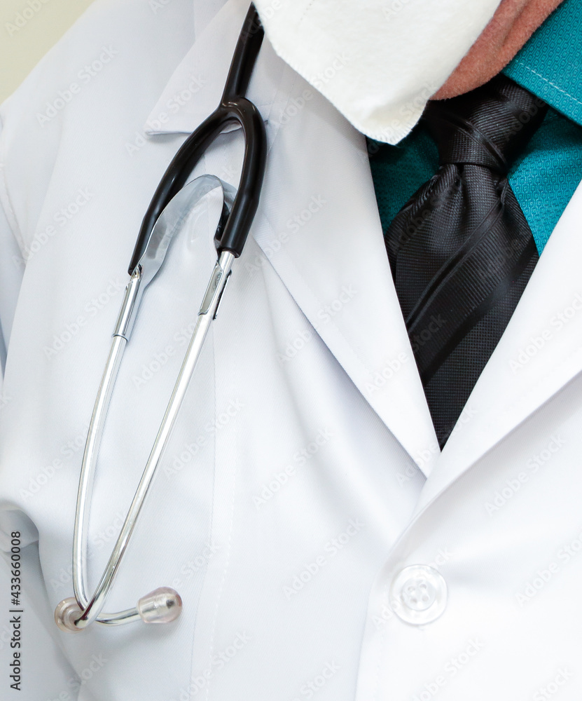 Medical stethoscope on the professional's neck over the lab coat, without showing the professional's face Medical stethoscope on the professional's neck over the lab coat, without showing the professional's face