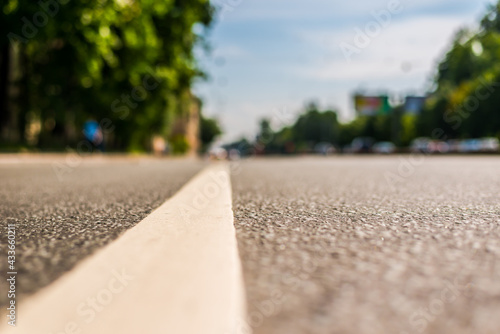 Summer in the city, the empty street. Close up view from the level of the dividing line