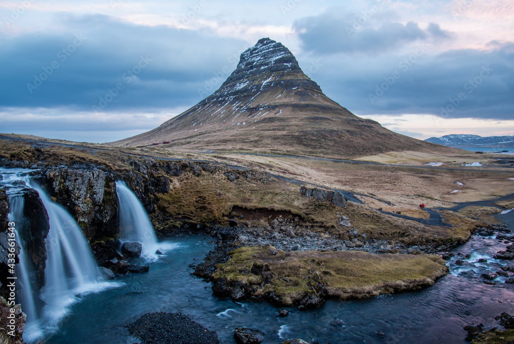 Long exposure at the Snæfellsnes Peninsula landmark view of Snæfellsjökull Volcano. Golden Circle views waterfall flowing dramatic landscape.