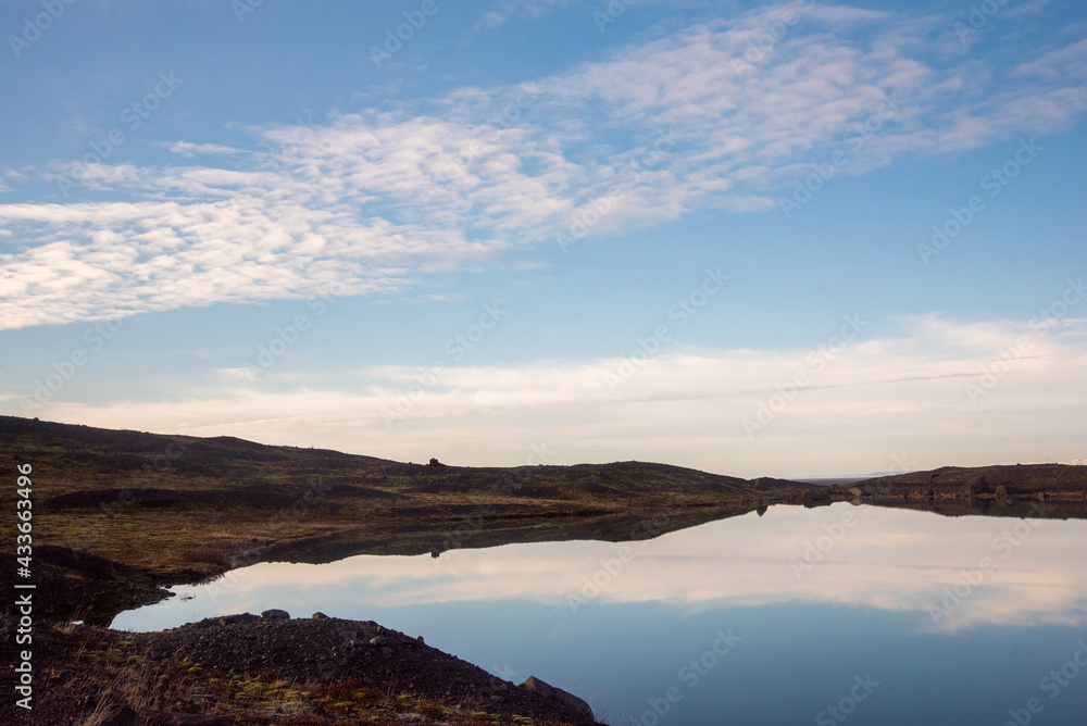 Atmospheric Iceland landscape with blue sky and clouds reflected on water