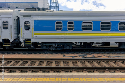 The blue carriage of a passenger train is at the platform. Passenger electric train at the railway station