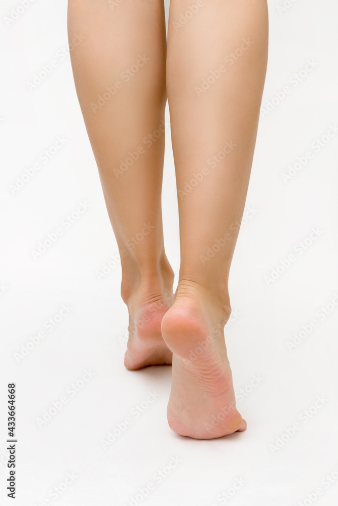 beautiful healthy slim women's feet, heels of feet on a white background, the concept of foot, heel and foot care beautiful healthy slim women's feet, heels of feet on a white background, the concept of foot, heel and foot care