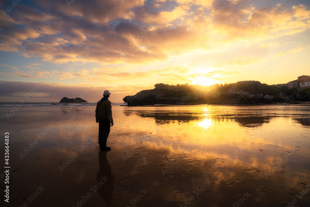 Unrecognizable man enjoying a sunset by the sea on a summer day Unrecognizable man enjoying a sunset by the sea on a summer day