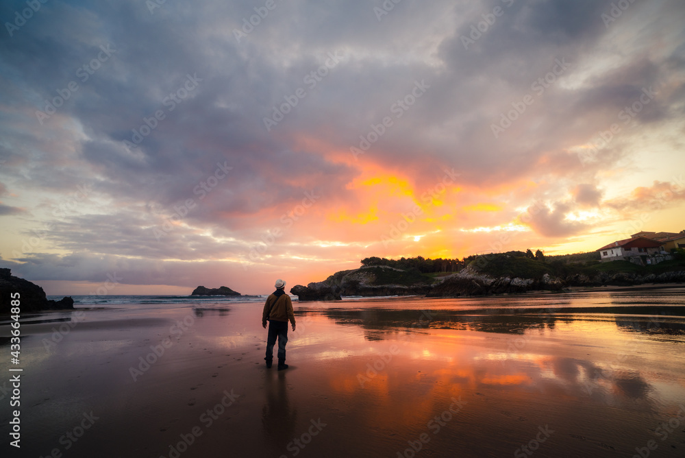 Unrecognizable man enjoying a sunset by the sea on a summer day Unrecognizable man enjoying a sunset by the sea on a summer day