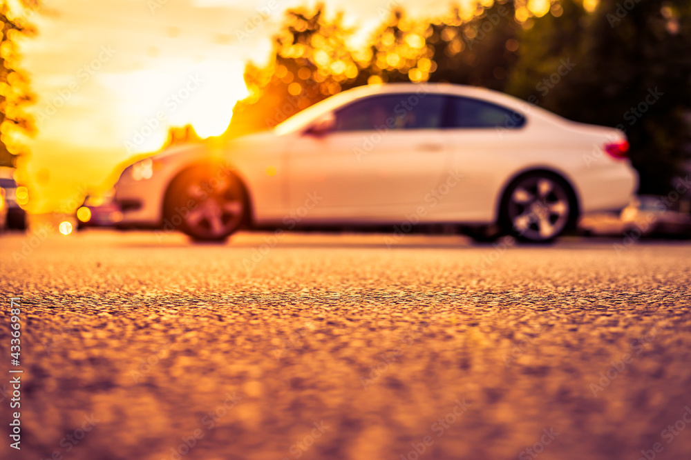 Sunset in the suburbs, the car drives off the highway. Close up view from the asphalt level